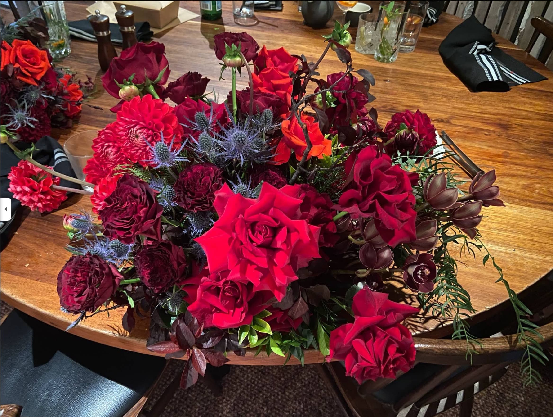 A lush red rose and dahlia centrepiece by The Flower Room