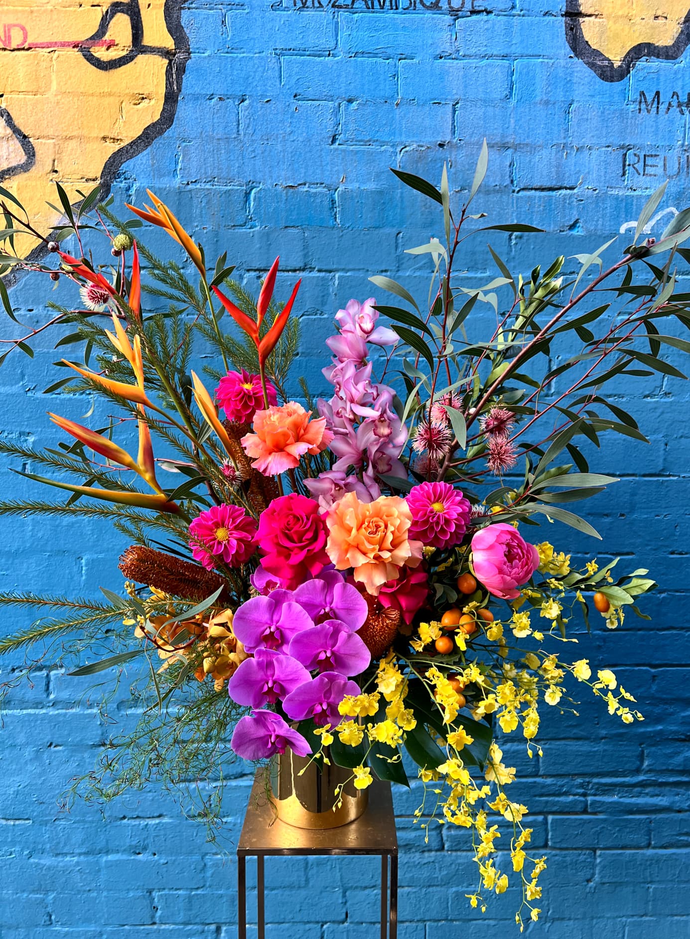 A bold seasonal arrangement from The Flower Room on a gold stand